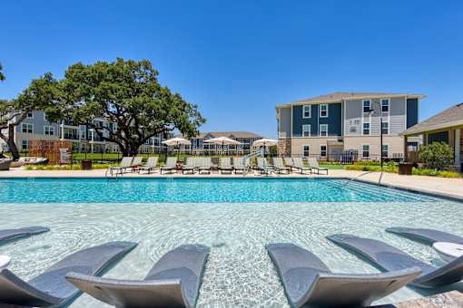 our apartments have a resort style pool with lounge chairs at Estraya Boerne, Texas
