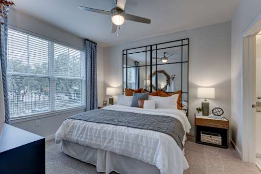 create a bedroom that is spacious and cozy with a large bed and a ceiling fan at Estraya Boerne, Texas, 78006