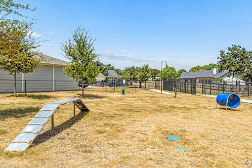 A playground with a slide, swings, and a seesaw.