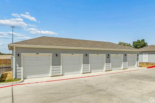 A building with a brown roof and white garage doors.
