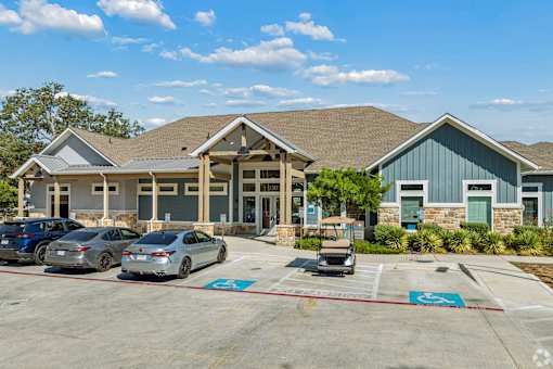 A parking lot with cars and a building in the background.