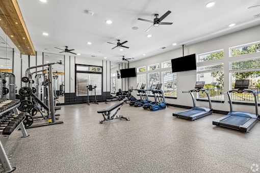 A spacious gym with treadmills, weights, and exercise equipment.