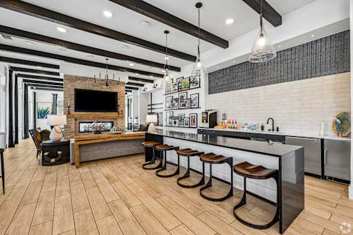 A modern kitchen with a bar area and a television above the island.