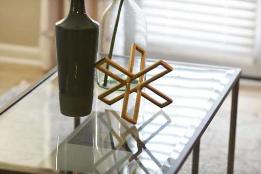 A bottle of wine and a wooden star-shaped object on a glass table.at Addison at Sutherland, Tennessee, 37909