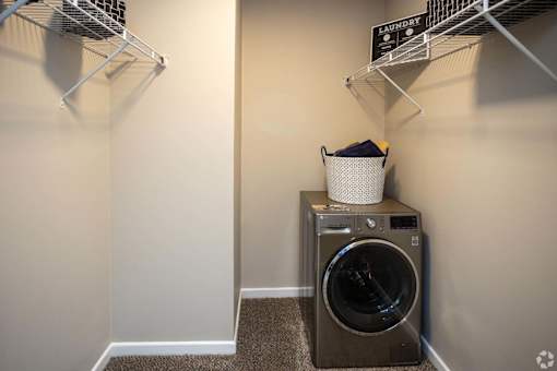 A laundry room with a washer and dryer and a basket on top of the dryer.at Addison at Sutherland, Tennessee, 37909