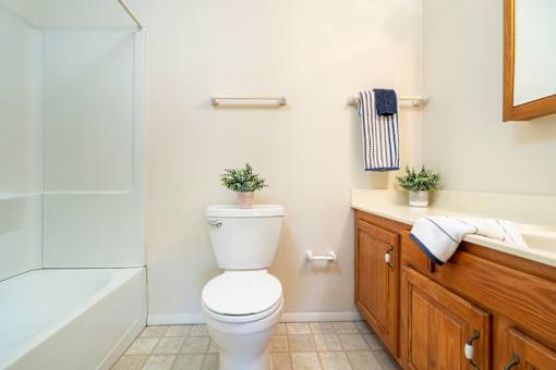 A white toilet sits in a bathroom next to a sink.