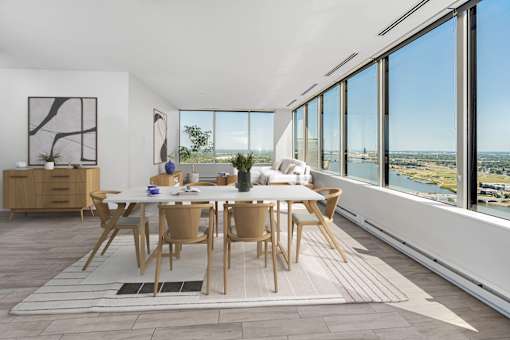 a dining room with a white table and chairs and large windows