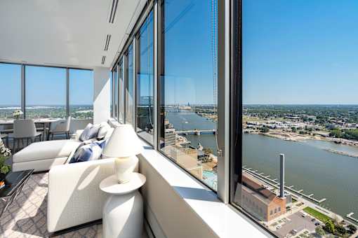 a room with a view of a river and a city from a skyscraper