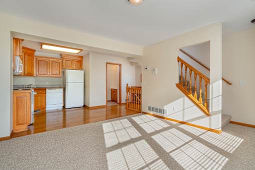 A spacious living room with a staircase leading to the upper floor.