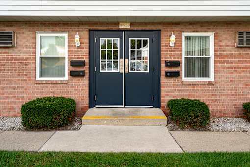 A house with a black front door and two windows on either side.