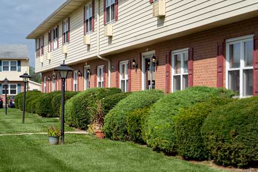 A building with a green lawn in front.