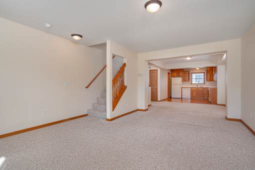 A spacious living room with a staircase leading to the upper floor.