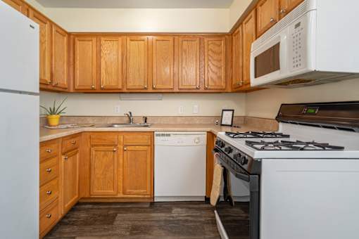 A kitchen with wooden cabinets and white appliances.