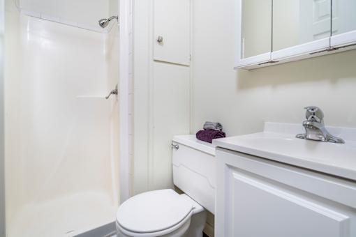 A white toilet sits next to a white sink in a bathroom.