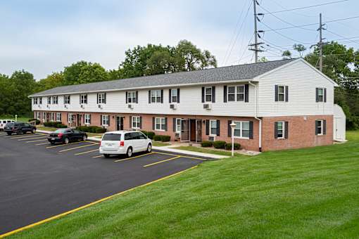 A white building with a parking lot in front.