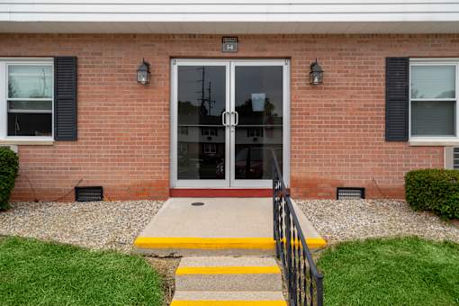 A brick house with a glass door and a yellow step.