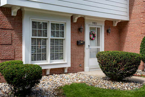 A house with a white door and window is numbered 5521.