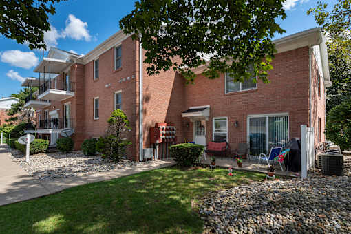 A red brick apartment building with a green lawn in front.