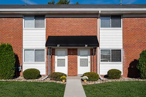 A brick building with a white door and windows.