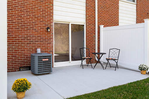 A patio with a table and chairs and a potted plant.