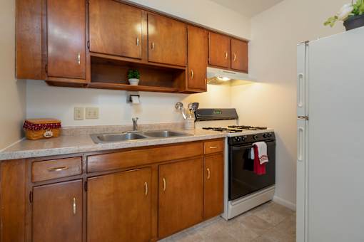 A kitchen with wooden cabinets and a white refrigerator.