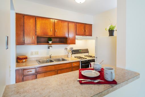 A kitchen with brown cabinets and a granite counter top.