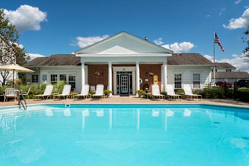 A white house with a pool in front.