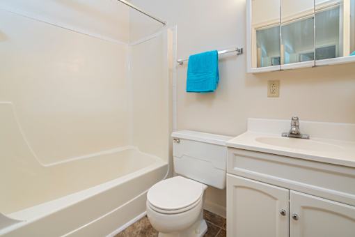 A white bathroom with a toilet, sink, and bathtub.