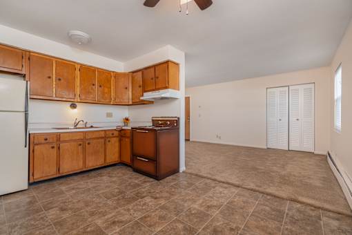 A kitchen with wooden cabinets and a white refrigerator.