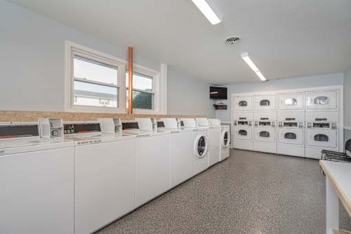 A laundromat with rows of washers and dryers.