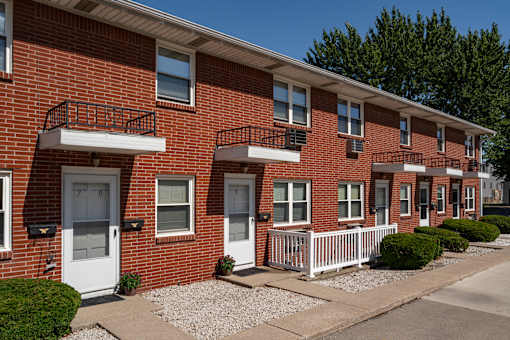 A row of red brick houses with white doors and windows.