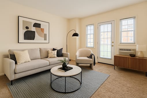 A living room with a grey couch, a black floor lamp, and a framed picture on the wall.