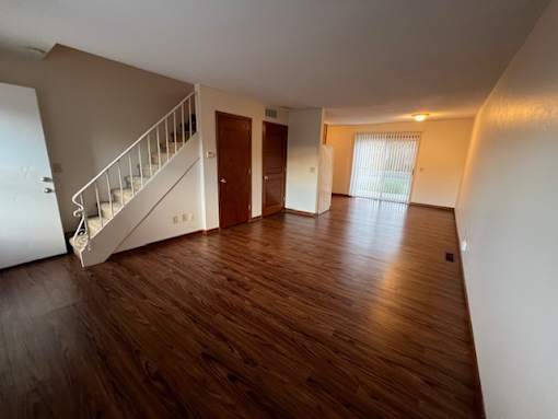 A room with wooden floors and a staircase.