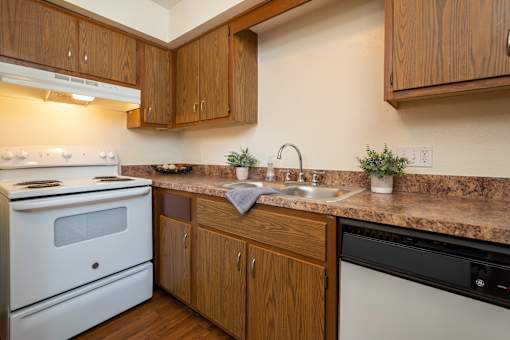 A kitchen with a white stove and wooden cabinets.