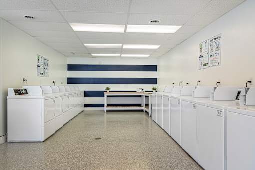 A laundromat with rows of washers and dryers.
