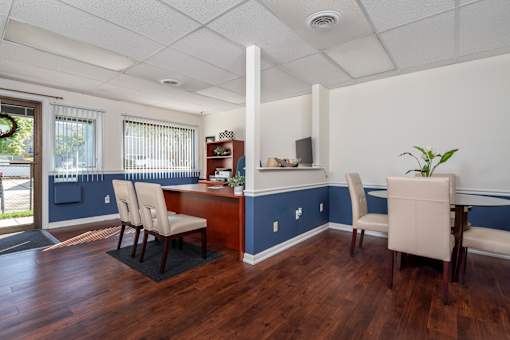 A room with a desk and chairs.