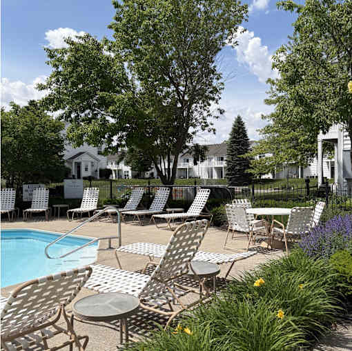 A poolside area with chairs and tables.