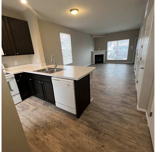 A kitchen with black cabinets and white appliances.