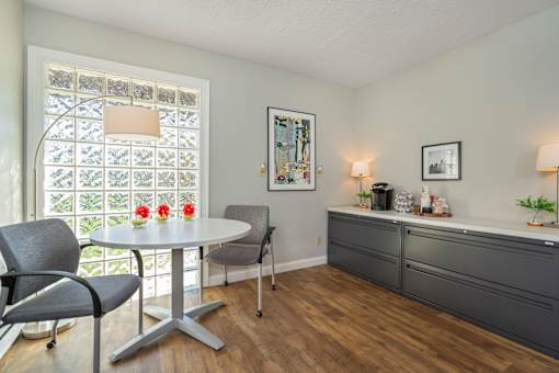 A dining room with a table, chairs, and a window with a lattice design.