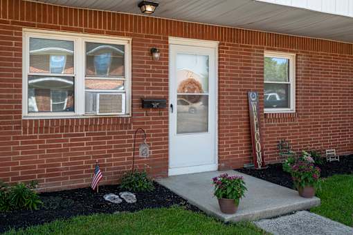 A brick house with a white door and a mailbox.