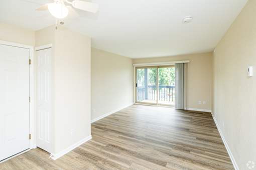 A room with a sliding glass door leading to a balcony.