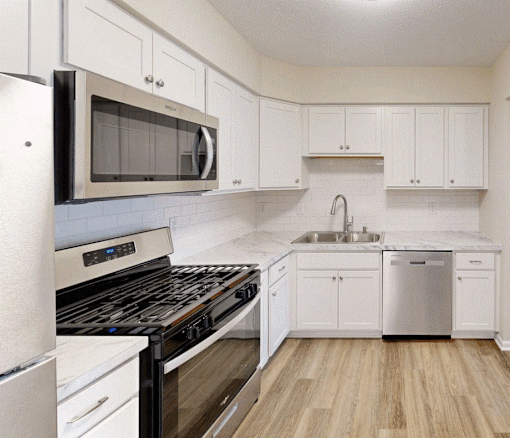 A kitchen with white cabinets and a black stove top oven.