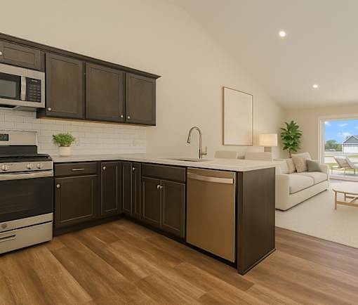 A modern kitchen with dark brown cabinets and a white brick backsplash.