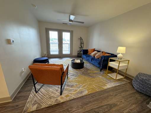 A living room with a blue couch and an orange chair.