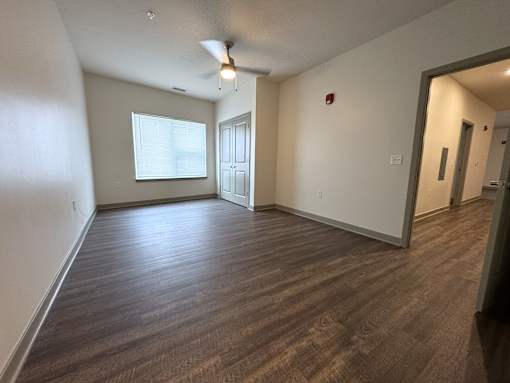 A room with wooden flooring and a ceiling fan.