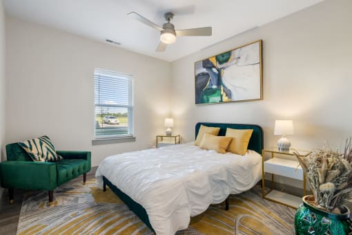 a bedroom with a bed and a chair and a ceiling fan at 41 North Apartments, Indiana, 46835