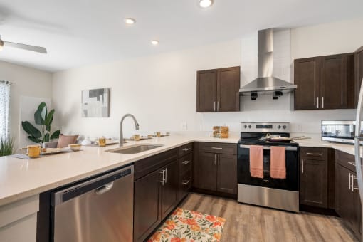 a large kitchen with stainless steel appliances and wooden cabinets at 41 North Apartments, Fort Wayne, IN 46835