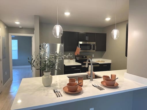 an open kitchen with black cabinets and a counter top at MountainView Flats, Glenwood Springs, CO, 81601