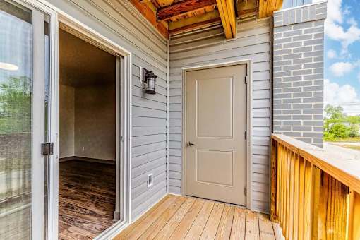 A white door is open to a room with a wooden floor.