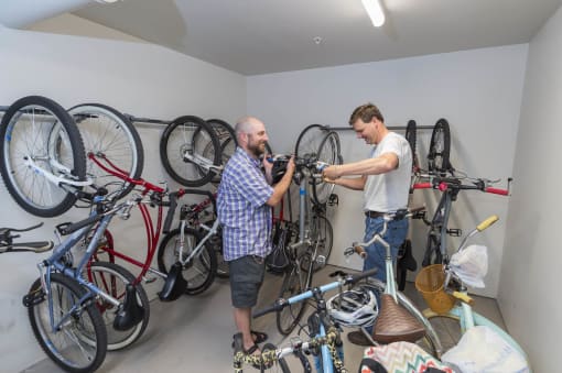 two men repairing bikes in a room with bikes on the wall  at Roaring Fork Apartments, Basalt, CO, 81621